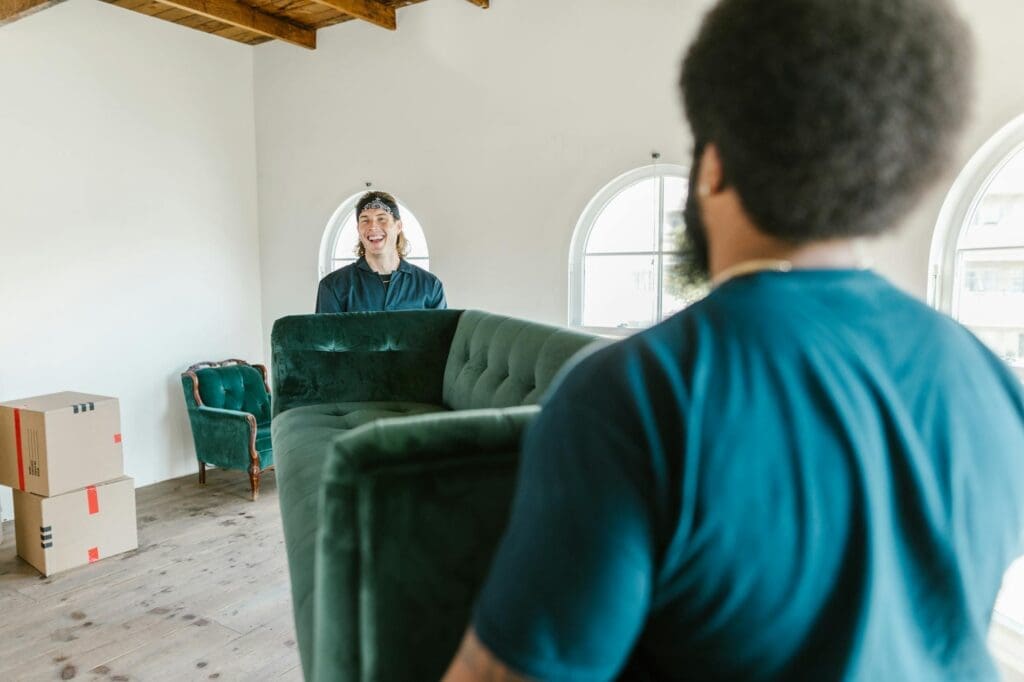 Two people carrying couch into home while relocating to reno nevada