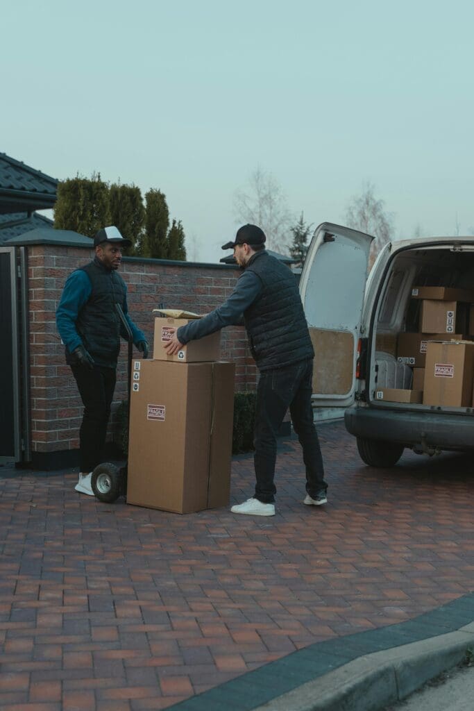 Two movers from Carson City moving companies loading boxes into a van.